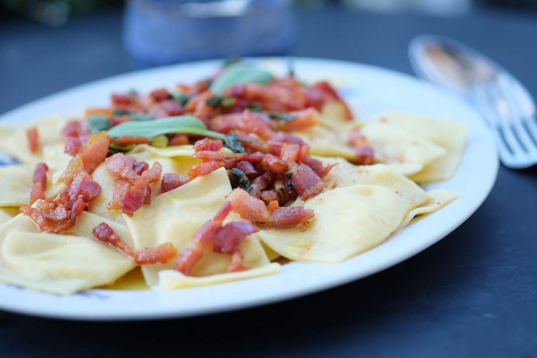 Deilig ravioli med potetfyll servert med baconsmør og salvie.