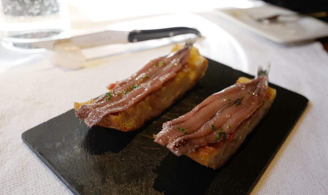 Perfekte ansjoser på grillet brød med tomat.